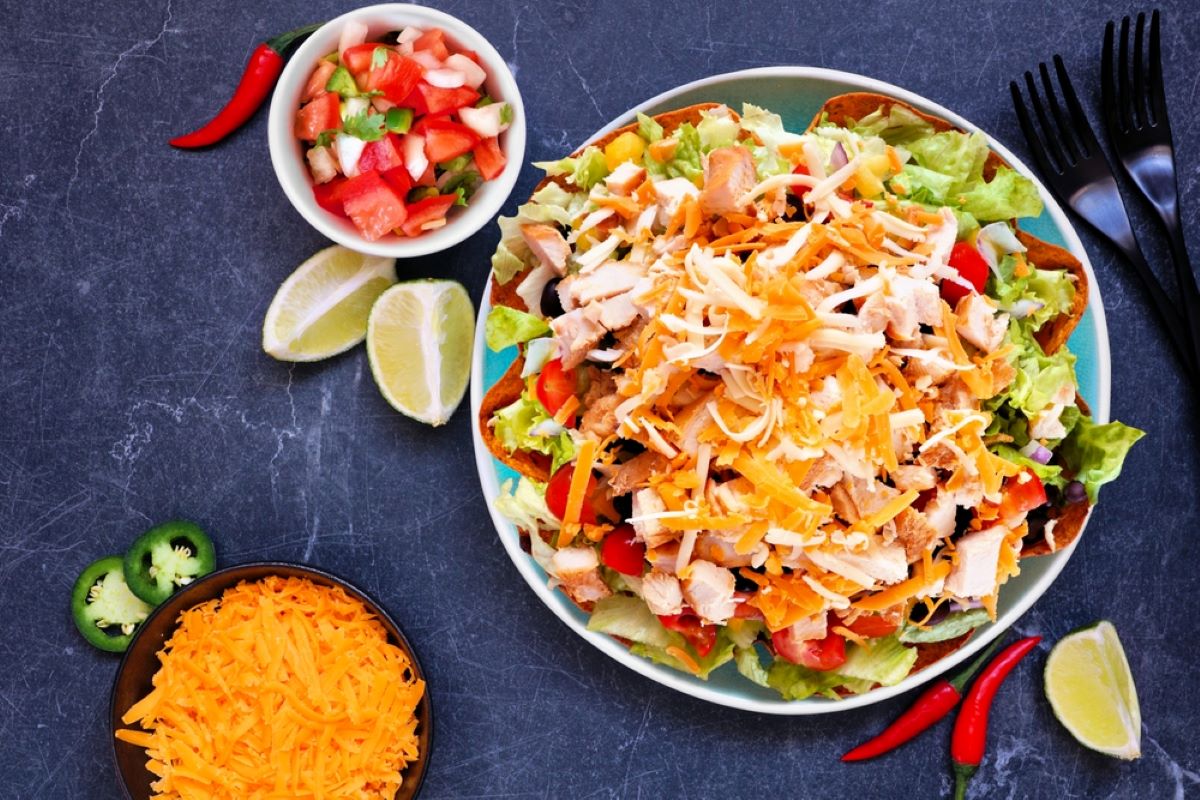 Chicken salad with chopped vegetables, tomatoes, and cheese.
